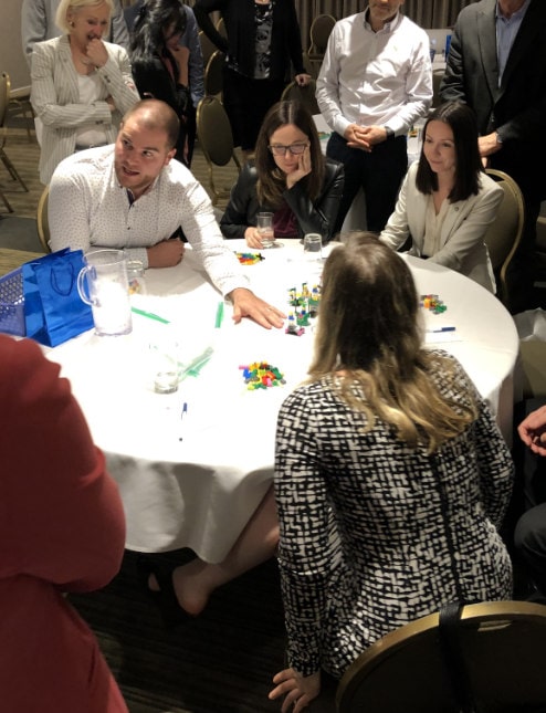 Un participant raconte l’histoire créée par son équipe avec les blocs Lego aux autres équipes.