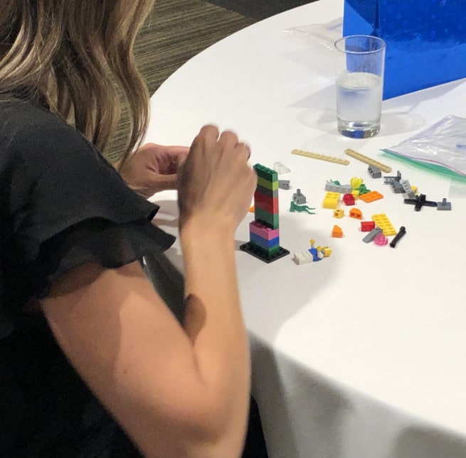 Une participante en pleine construction de sa création en blocs Lego.